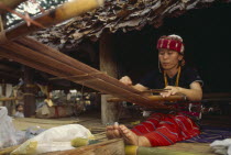 Sgaw Karen woman weaving cloth on a back strap loom