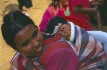 Lisu woman with her infant son carried papoose style on her back