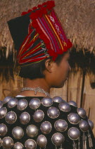 Back view of a Jinghpaw woman in traditional jacket and hat