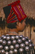Back view of a Jinghpaw woman in traditional jacket and hat