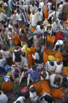 View looking down on busy flower market with a majority of male vendors selling mostly marigolds