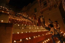 Deep Divali Festival. People lighting oil lamps on the steps leading down to the River Ganges