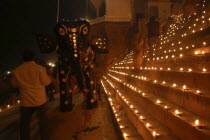Deep Divali Festival with paper statue of Hindu God Ganesh on steps of ghats lined with oil lamps leading to Ganges River