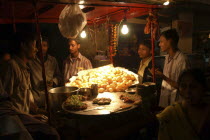 Young men buying snacks on the road at night dal mutt