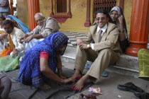 Sankat Mochan Mandir temple. Hindu wedding with the groom getting his feet painted auspicious red as his mother sits behind him