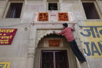 Deep Divali Festival with young man decorating a doorway