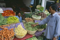 Pettah District. Customer at a market stall selling vegetables