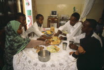 Middle class children eating lunch at home.  Food is taken from one central dish using right hand only.