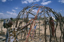 Women building frame of traditional nomadic house in Kandahr IDP camp.Internally Displaced Persons.  Ayaha returnee settlement