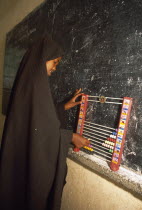 Ali Osman Primary School.  Girl using abacus in classroom.