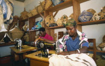 Women using sewing machines in dressmaking workshop in refugee camp.