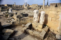 Agora.  Ruins of public square with two decapitated and armless statues in the foreground.