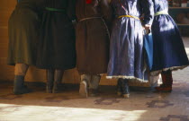 Cropped view of group of women standing at counter of shop.