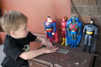 Boy age 4 playing with his action hero figures. Superman  The Flash  Martian Manhunter and Batman from Mattel and DC Comics Justice League