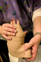 Emergency room nurse wrapping temporary elastic bandage on broken wrist.