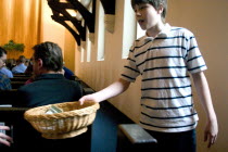 Young boy passing the offering basket at Unity Church Unitarian.