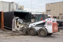 Bobcat a front end loader removing items from the appliance bin in the Vasko Disposal Solutions junk yard.