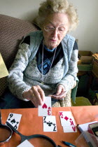 Elderly woman playing Solitaire card game with large print cards.Aunt Fran age 92 suffering from macular degeneration a breakdown of light-sensitive cells in the central area of the retina making rea...