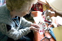 Elderly woman playing card game with large print cards.Aunt Fran age 92 suffering from macular degeneration a breakdown of light-sensitive cells in the central area of the retina making reading and c...