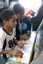 Friends age 11 playing video games developing their eye hand coordination at the Youth Express inner city activity center. Centre