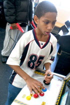 Young black child aged 10 playing video games developing his eye hand coordination at the Youth Express inner city activity center.Centre