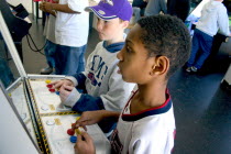 Friends age 10 playing video games developing their eye hand coordination at the Youth Express activity center. Centre