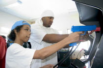 Youth Express Leader and member age 19 and 13 shooting Point Blank video game with red and blue replica 45 caliber plastic pistols.