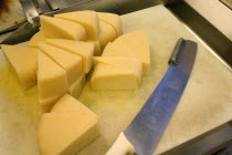 Wedges of freshly cut Park brand Parmesan Cheese from Wisconsin at the Mississippi Market a natural foods co-op located at Dale and Selby  waiting to be wrapped  weighed and packaged.