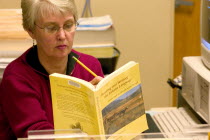 Librarian at the Franklin Public Library finding a reference in the Lakota Language textbook.
