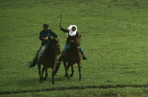 Kazakh traditional race on horseback called Kuuz Kuu or Catch the Girl.  The girl may whip the boy chasing her but if successful in catching her he earns a kiss.