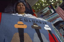 Ecuadorean Otavalan Indian woman selling textile souvenirs.