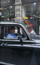 Detail of London cabbie in his taxi
