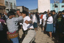 Traditional Tinku fighting festival.  Crowds watching two young men fighting in street.
