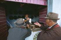 Hat maker in La Ceja exchanging money with customers.Gray Grey