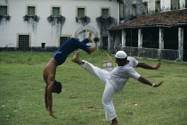 Traditional African derived martial arts form performed to the sound of the berimbau one stringed bow and resonator and accompanying chant.Brasil Brazil