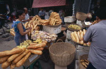 Market stall selling bread and bananas with customersAsian Cambodian Kampuchea Southeast Asia Kamphuchea