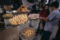 Market stall selling bread with vendor and customerAsian Cambodian Kampuchea Southeast Asia Kamphuchea