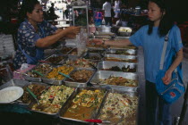 Woman selling cooked food to a local woman in an alley beside Patpong 1Asian Prathet Thai Raja Anachakra Thai Siam Southeast Asia Female Women Girl Lady Siamese Female Woman Girl Lady