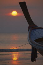 Klong Dao beach at sunset with the bow of a fishing boat pointing out to sea