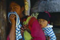 Lisu woman carrying her child in sling on her back.