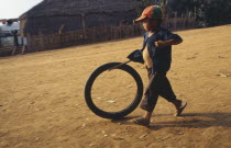 Akha child playing with bike tyre.I-Kaw
