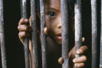 Portrait of a young Macuna Indian boy at the gate of his maloca. Tukano or Tucano group