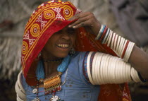 Bhansda village.  Smiling young woman from farming caste chodri wearing traditional jewellery.