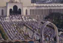 Muslim worshippers kneeling in prayer in courtyard of mosque. Moslem