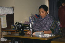 Tribal lady working at sewing machine.textiles