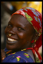 Smiling African woman wearing floral headscarf and small gold nose ring through her septum