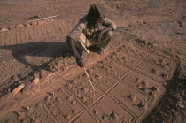 A fox diviner man indicating fox paw prints for telling fortunes.