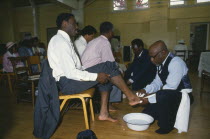 Pentecostal church service.  Members of the congregation taking part in the washing of feet ceremony.