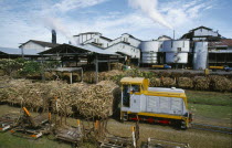 Viti Levu  south. Sugar cane refinery with train loaded with cut cane in the foreground.