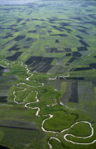 Aerial view over river meandering through agricultural land.